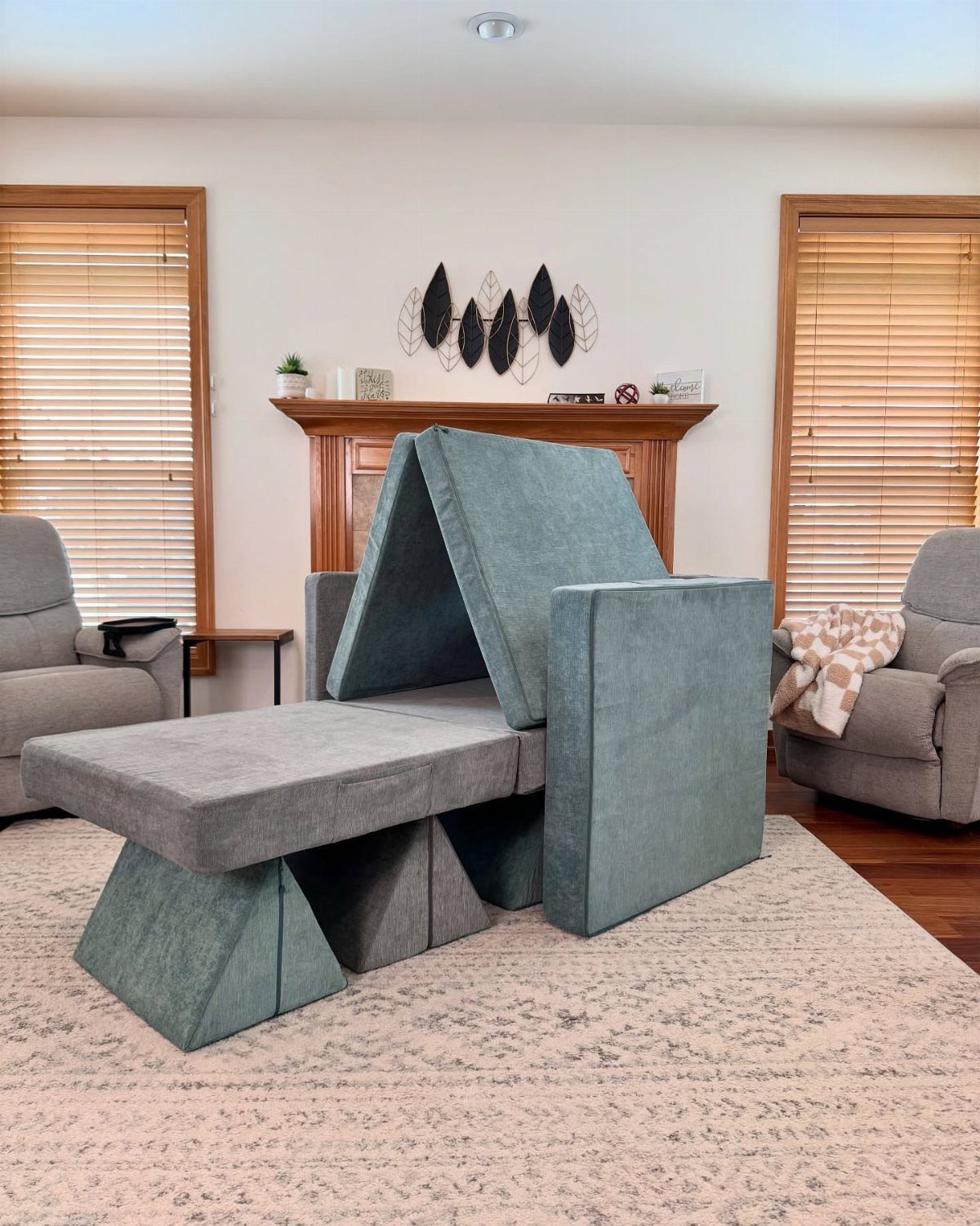 Grey foam play couch arranged as a fort in a bright living room.