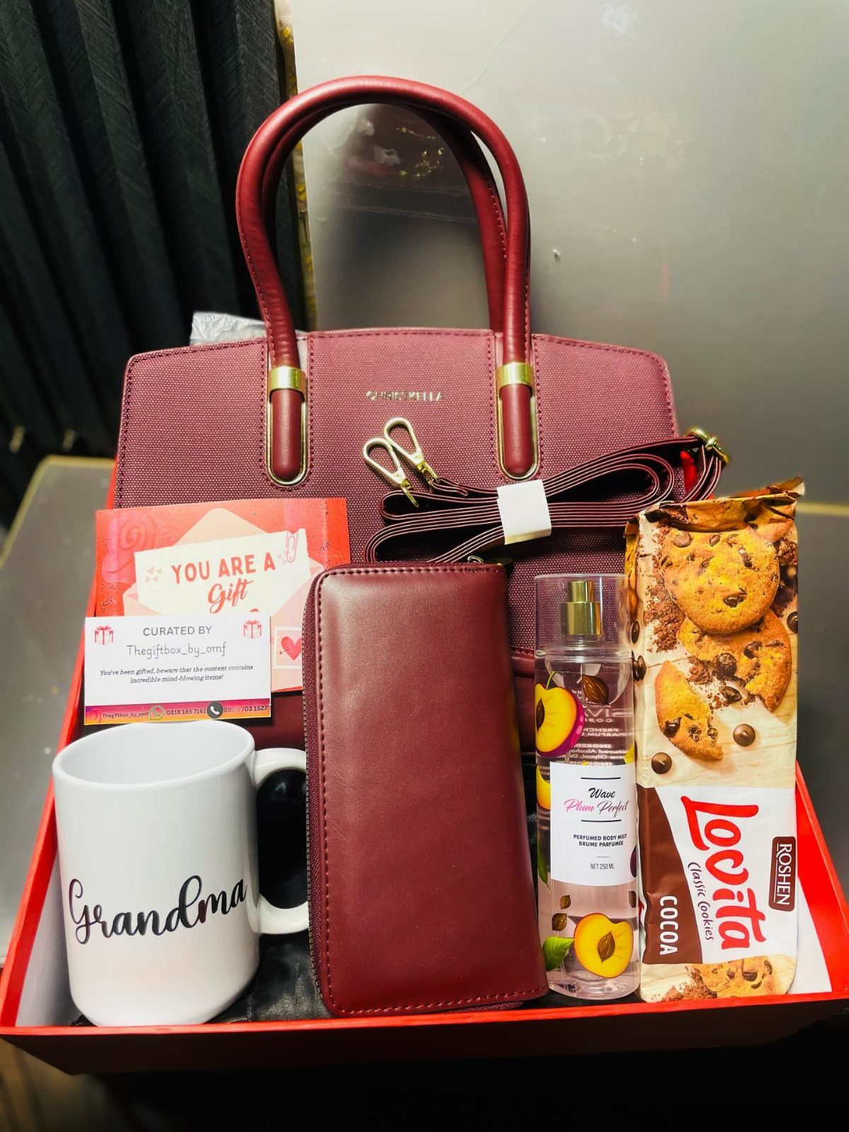 White mug with Grandma text in a red gift tray with handbag and cookies