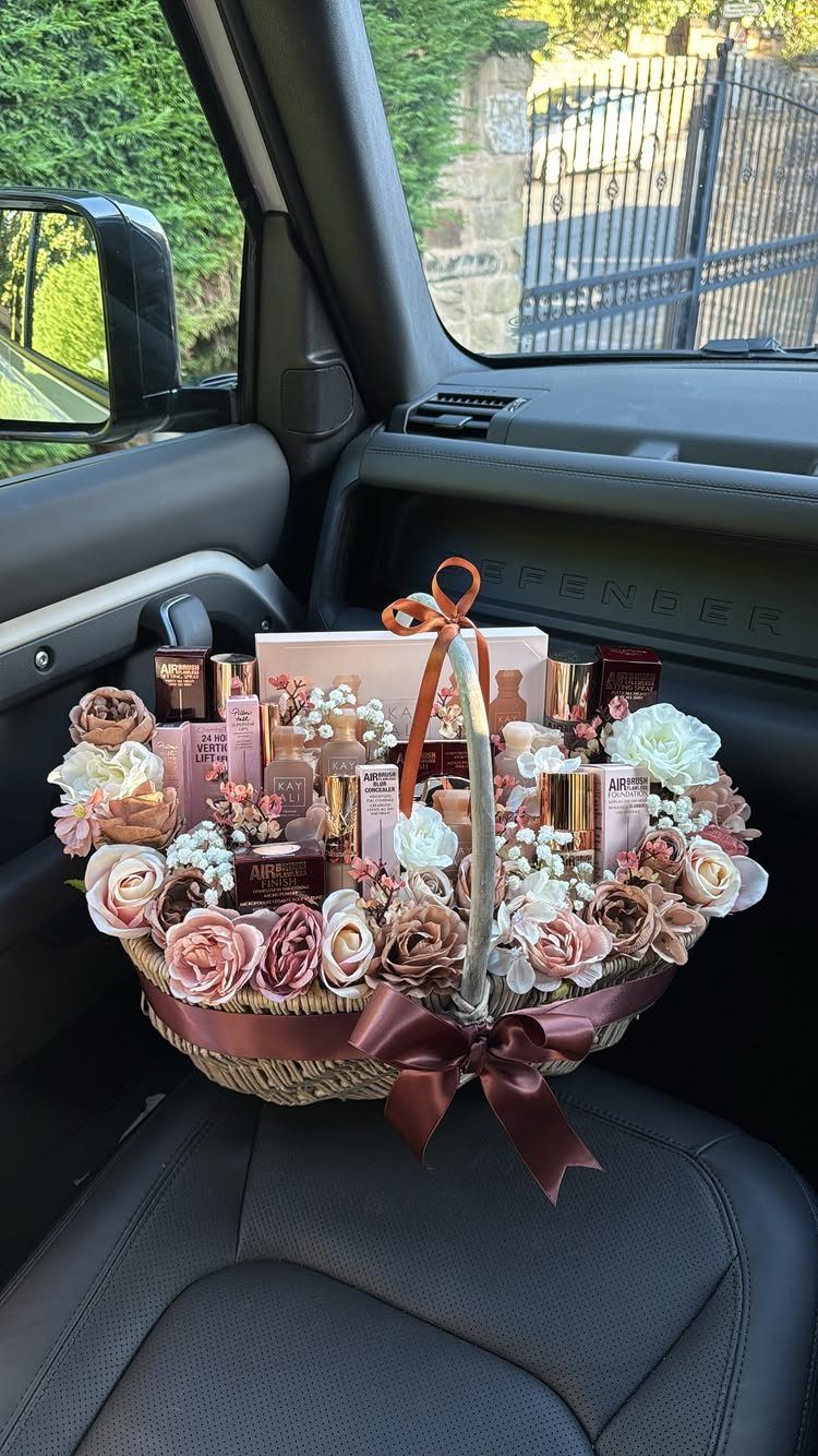 Wicker gift basket with beauty products and pink roses on a car seat