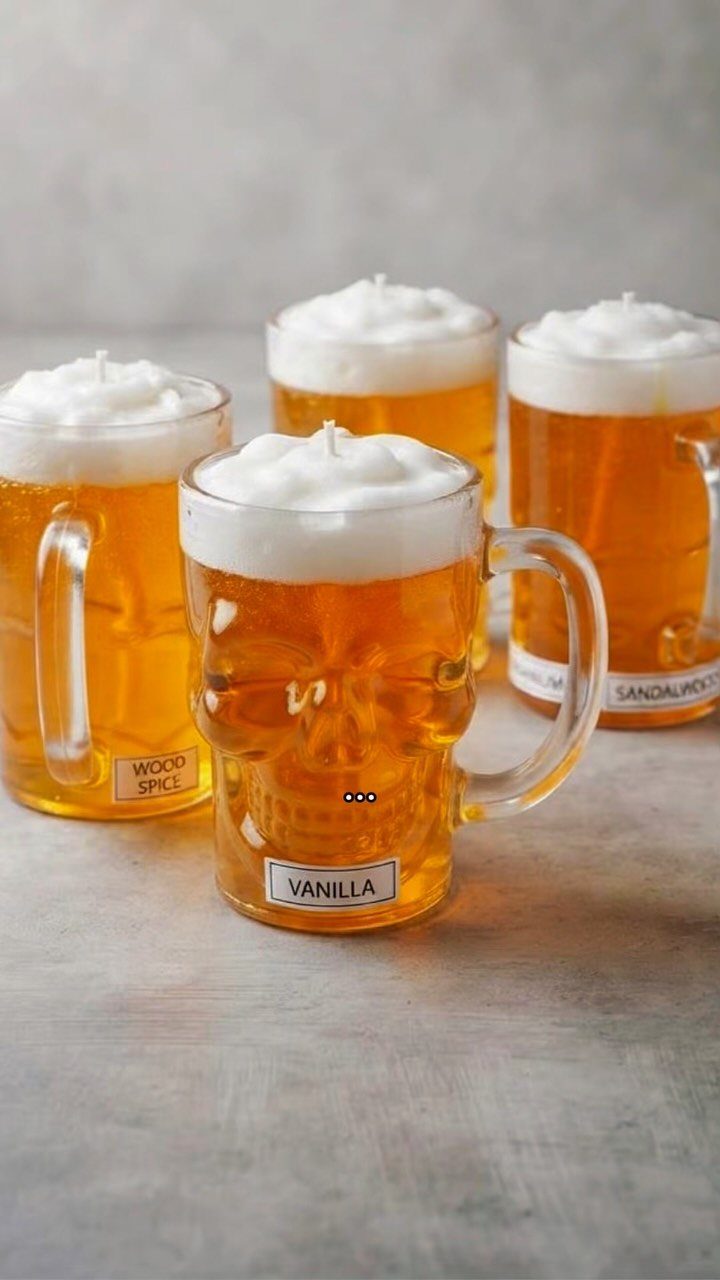 Skull-shaped beer mug candles with amber wax and white whipped cream tops.