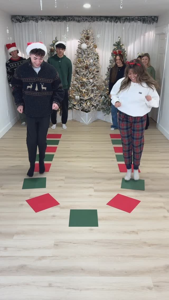 Young adults playing a game with red and green squares on a floor.