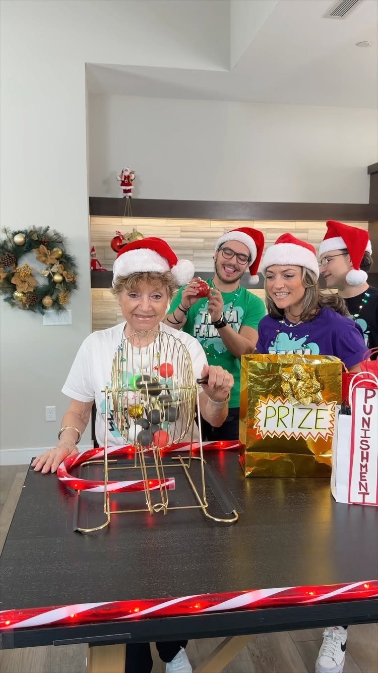 Adults in Santa hats playing a wire cage game with a prize bag.