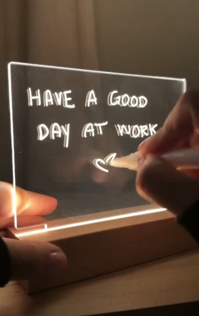 Acrylic LED memo board with a wooden base and handwritten work encouragement message.