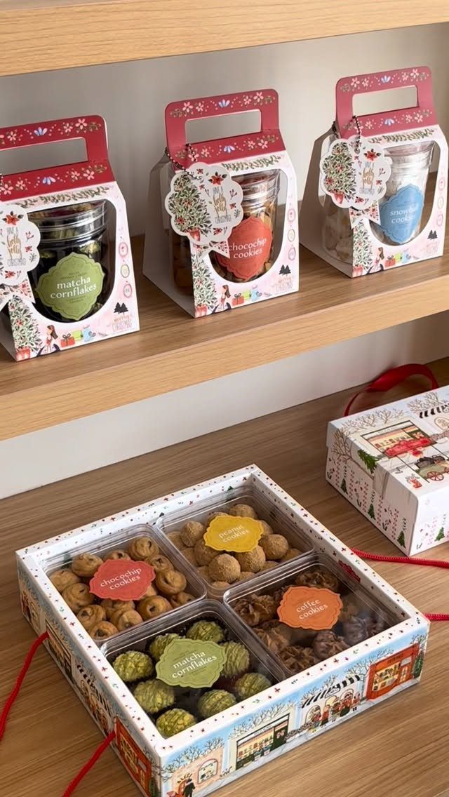 Assorted gourmet cookies in a decorative divided gift box on a wooden surface.