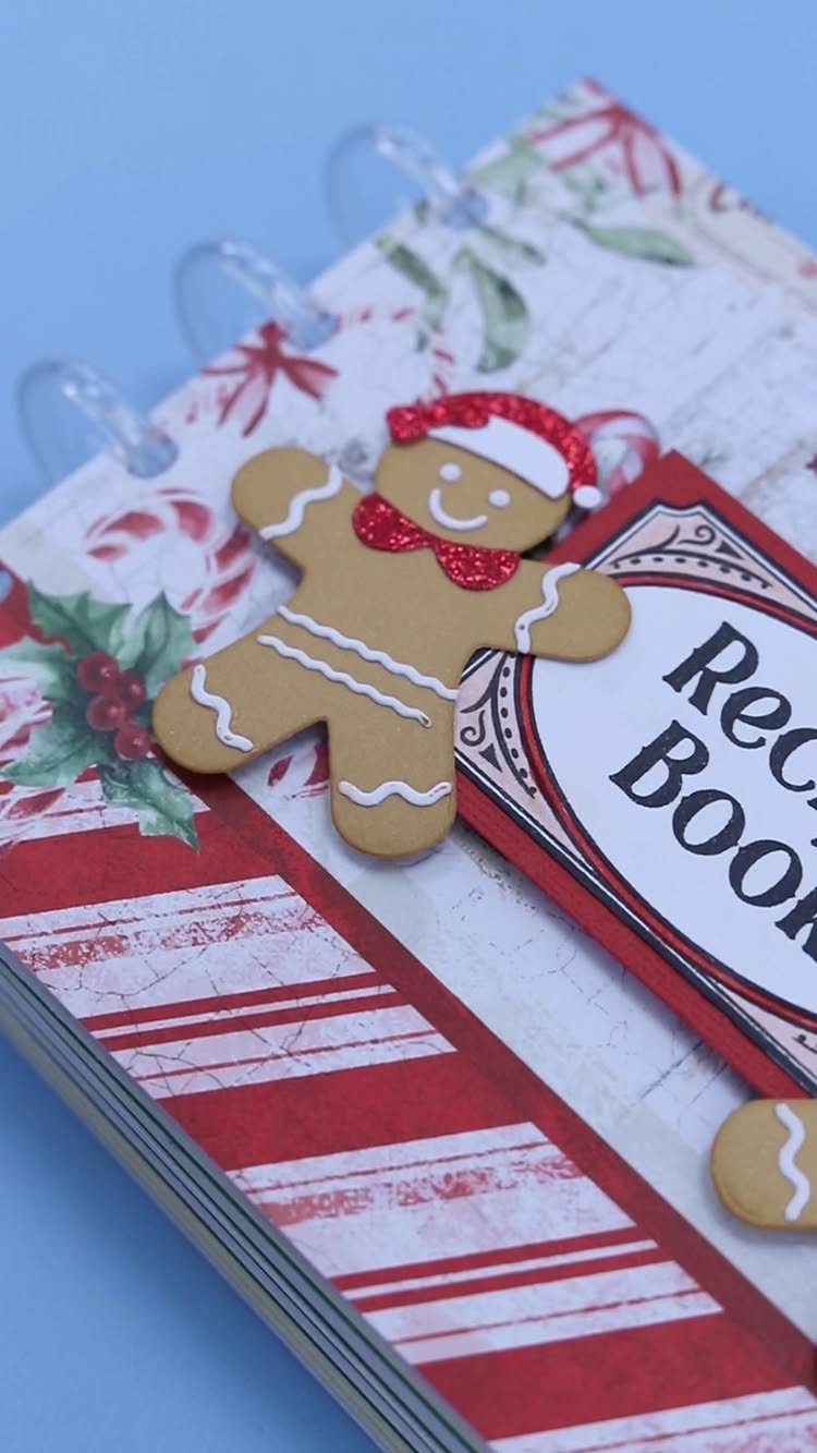 Handmade recipe book with a gingerbread man decoration and red festive patterns.