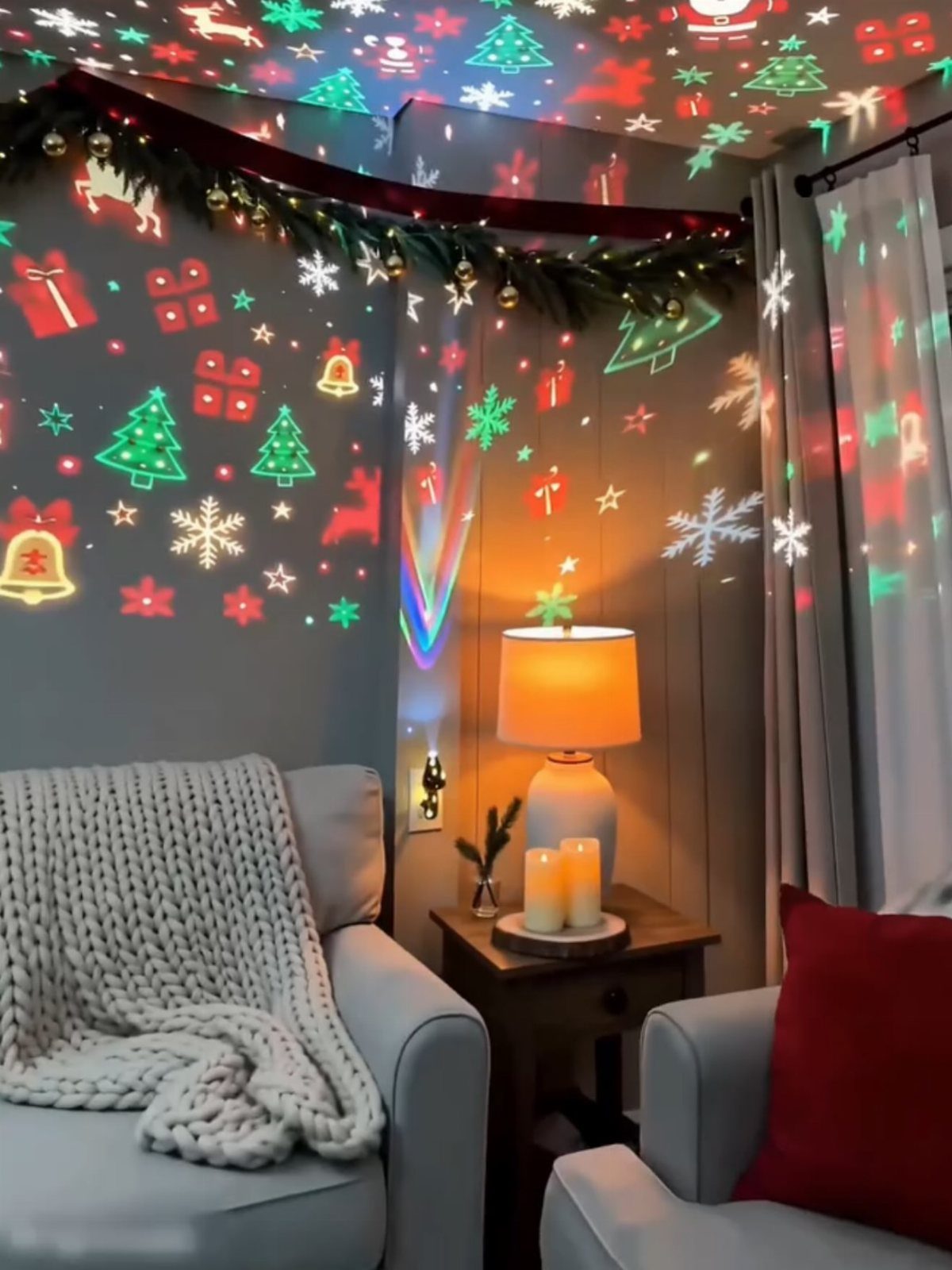 Cozy living room with Christmas light projections of trees and snowflakes on walls