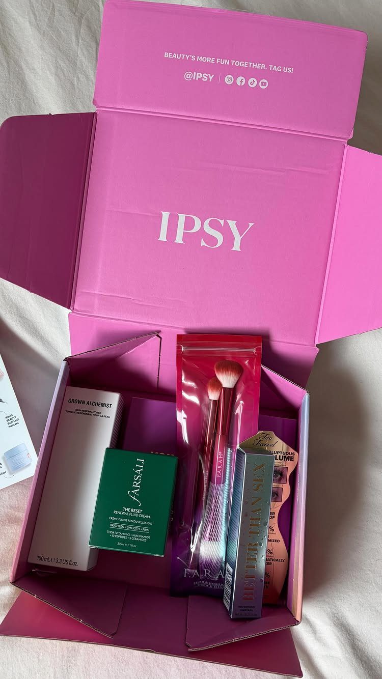 Open pink Ipsy subscription box filled with various makeup and beauty products.