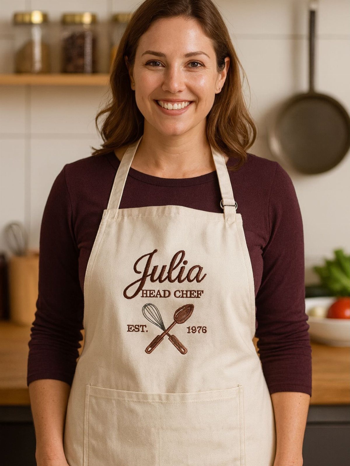 Woman wearing a personalized cream kitchen apron with the name Julia and chef title.