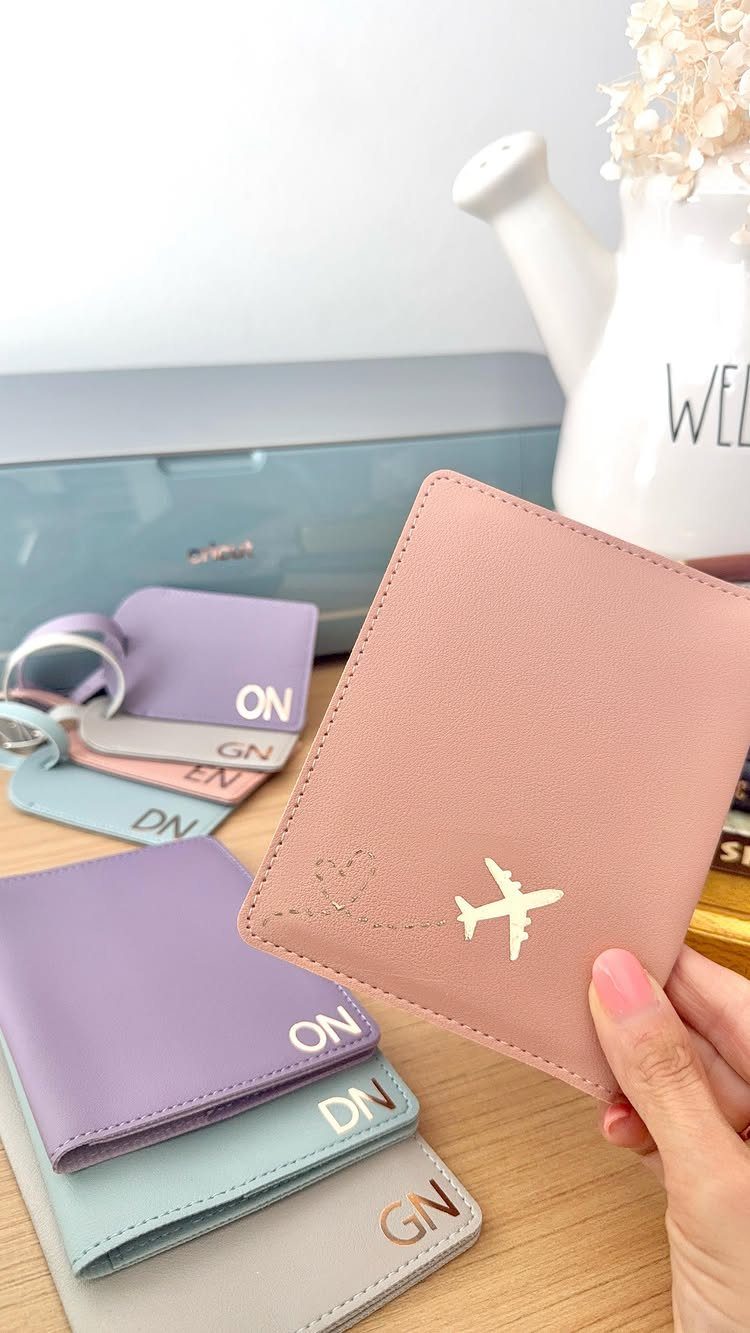 Pink personalized passport holder with gold airplane icon and matching luggage tags.