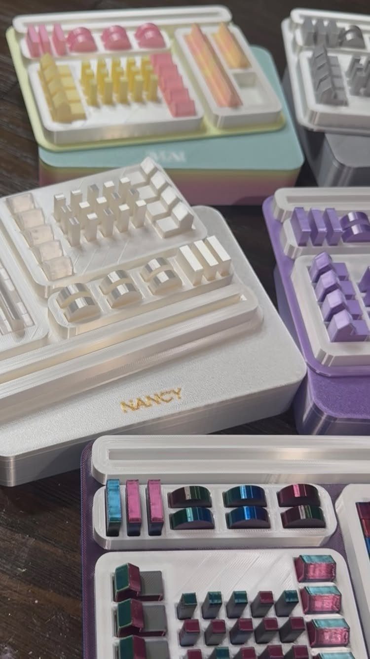 Colorful mechanical keyboard keycap sets in personalized containers arranged on a dark surface