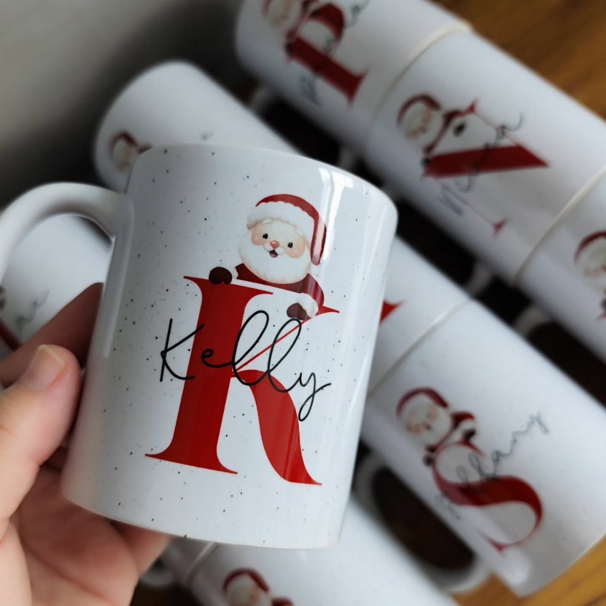 White ceramic mug with a red letter K, name Kelly, and Santa Claus