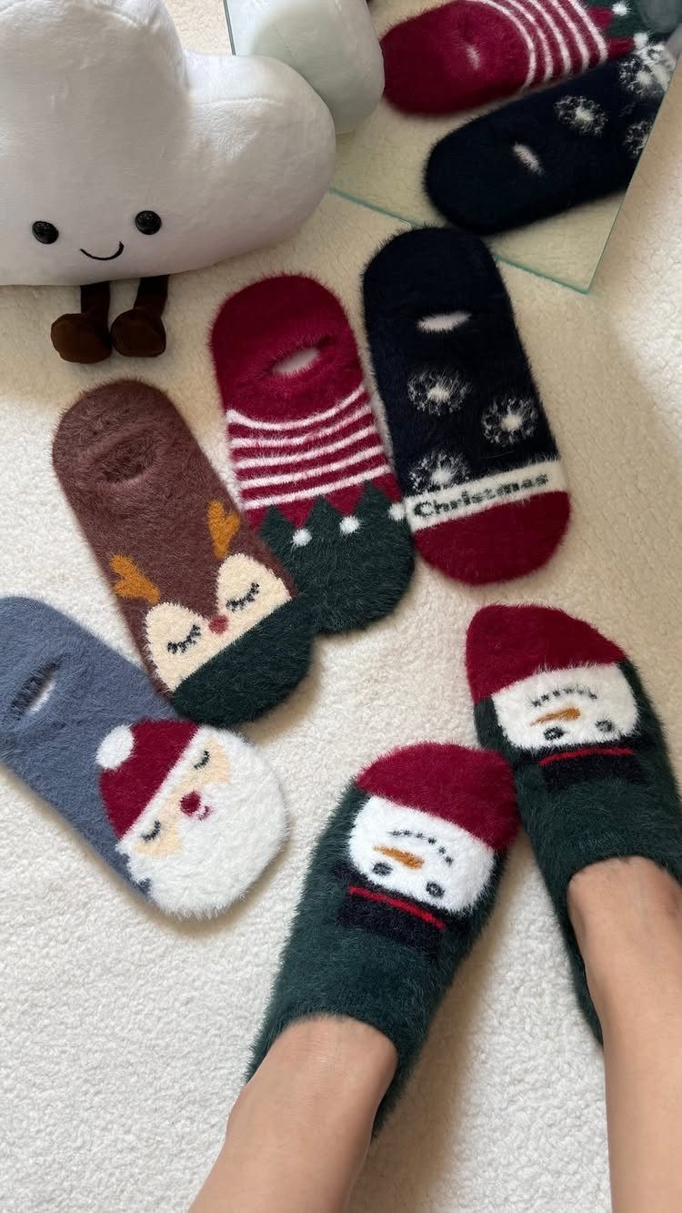 Christmas themed fuzzy socks with holiday characters on a white fluffy rug