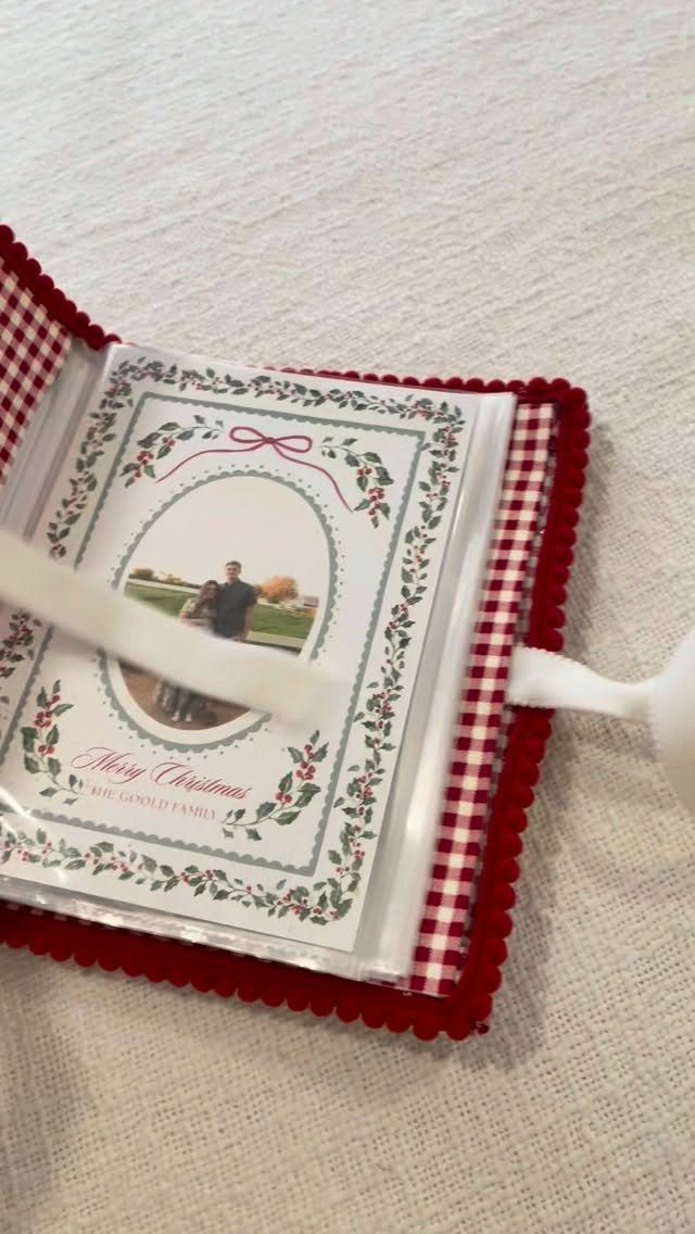 Red checkered photo album containing a Christmas card with a couple's photograph.