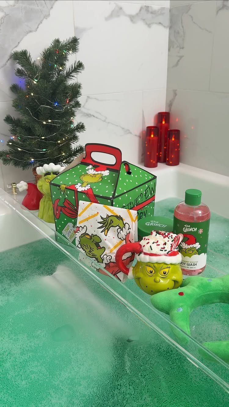 Grinch-themed Christmas gift set with a mug and bath products in green water.