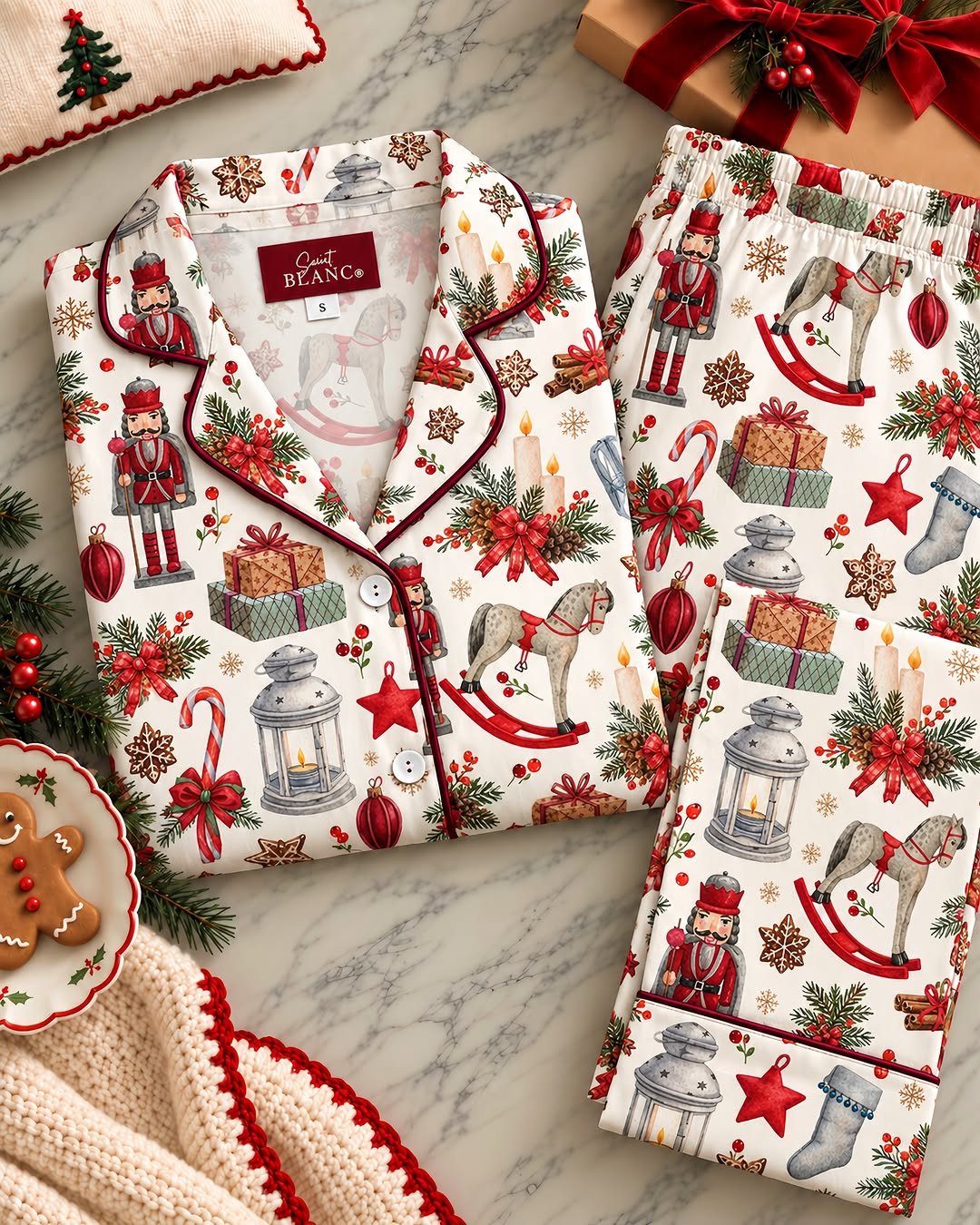 White Christmas themed pajama set with nutcrackers and rocking horses on marble surface.