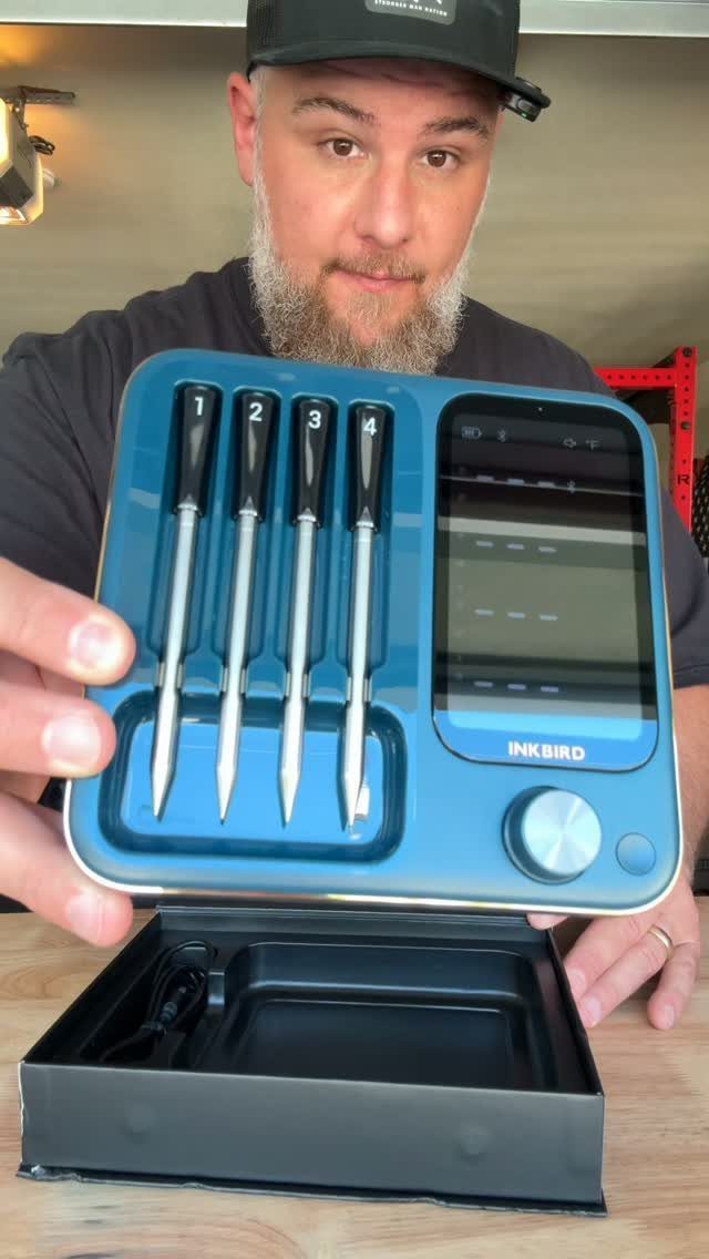 Man holding a blue Inkbird digital meat thermometer kit with four probes.