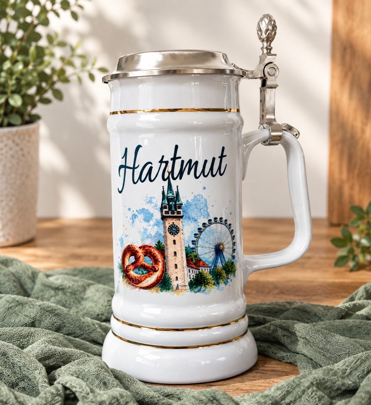 White ceramic beer stein with silver lid and personalized name Hartmut and city illustration.