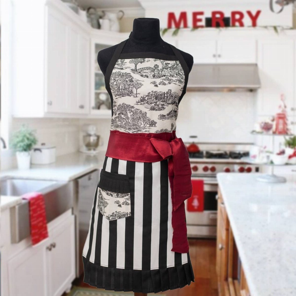 Patterned black and white apron with red bow on a mannequin in kitchen
