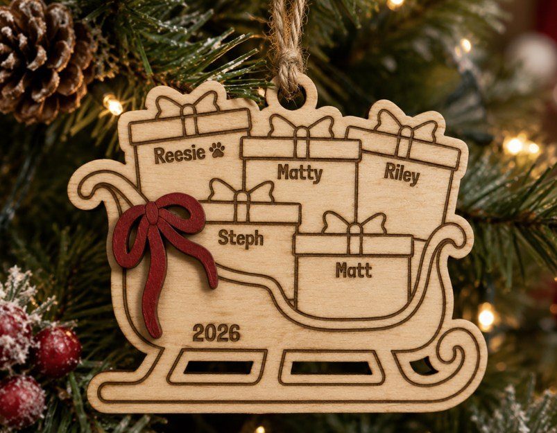 Wooden sleigh ornament with engraved names on gifts hanging on a Christmas tree