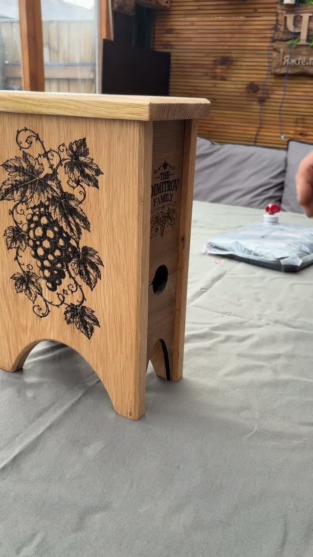 Wooden wine box with engraved grape vines and personalized family text on side.