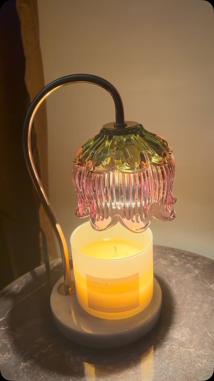 Candle warmer lamp with a colorful flower glass shade warming a white candle.