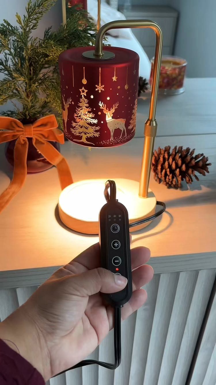 Red Christmas themed lamp with gold reindeer patterns and a remote control