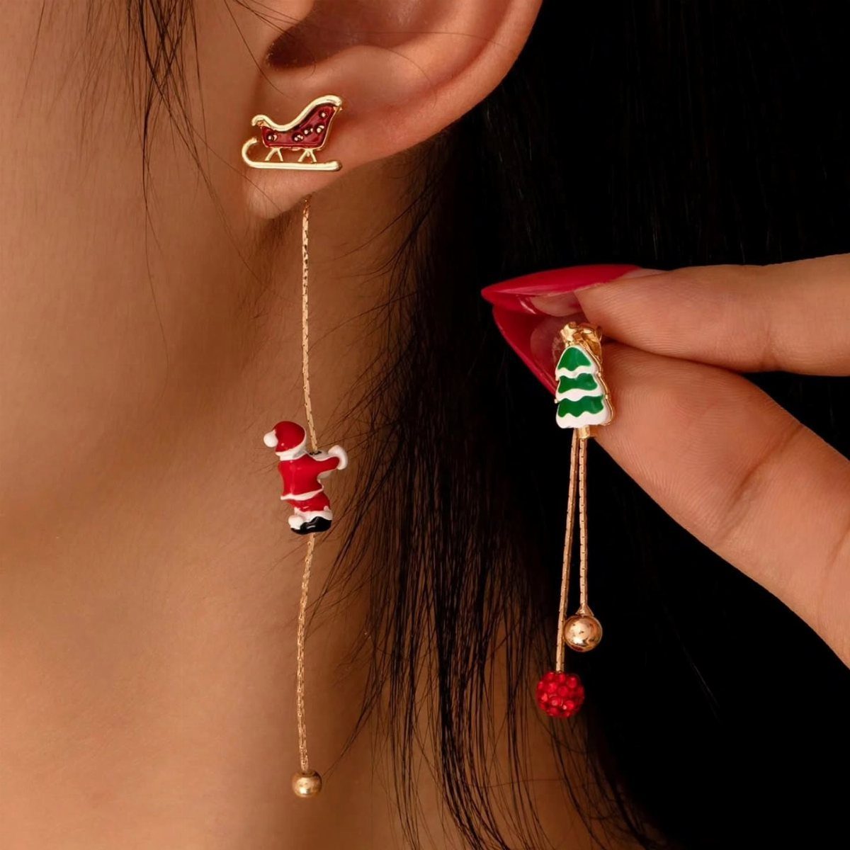 Christmas themed gold earrings featuring a sleigh, Santa Claus, and a small tree.