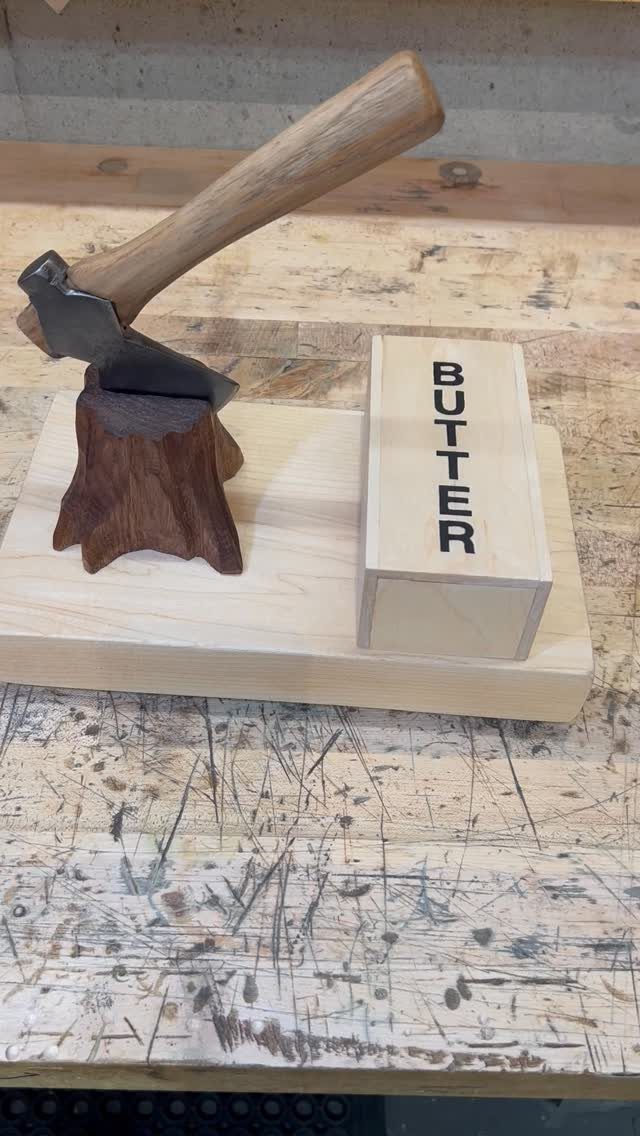 Small decorative axe and butter block on a wooden base for novelty gifting.