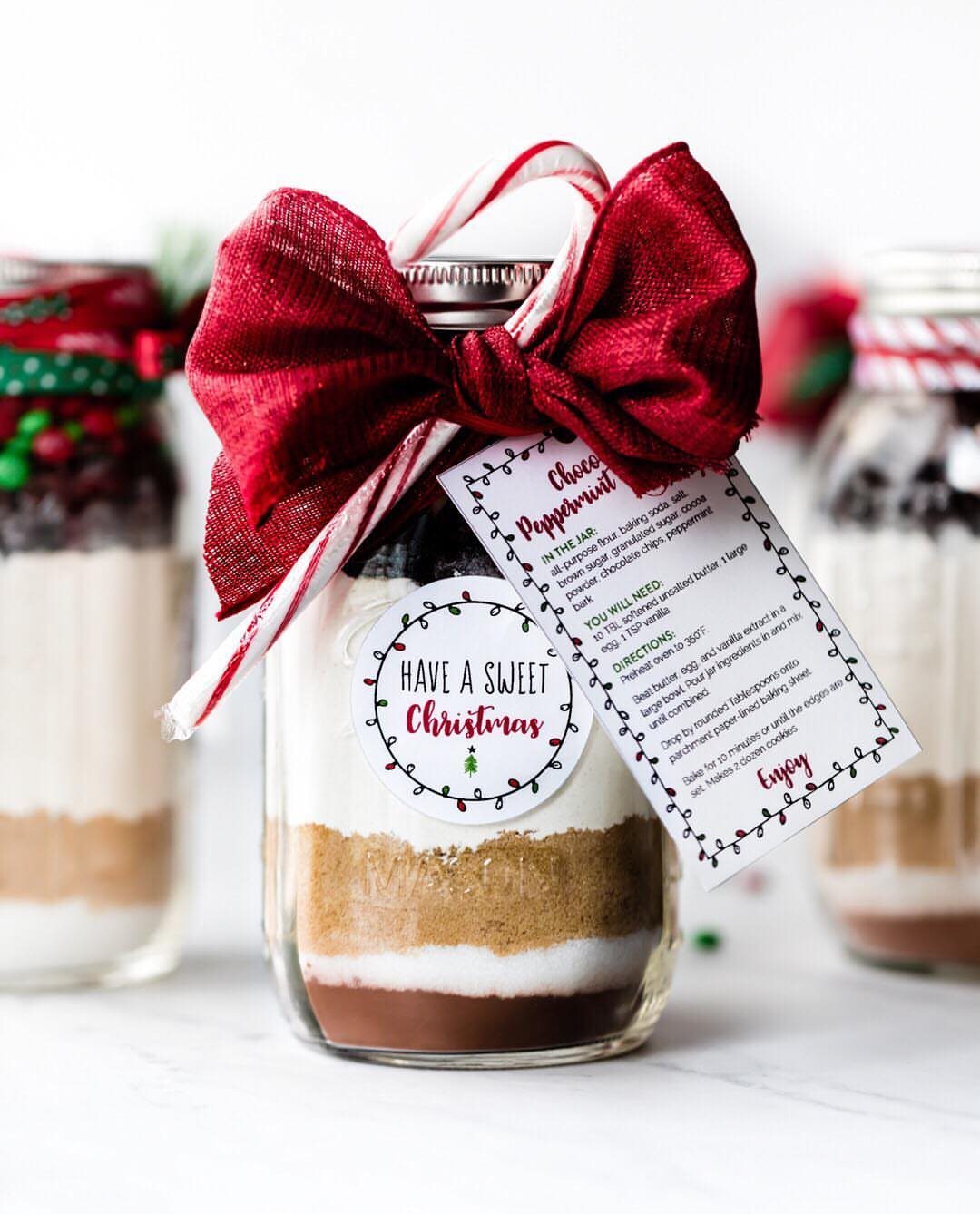 Layered cookie mix in a mason jar with a red bow and gift tag.