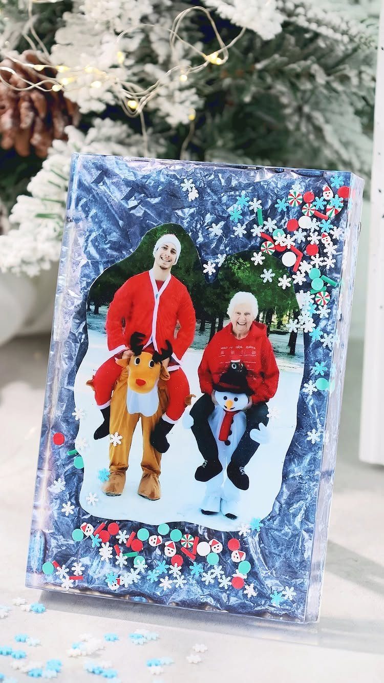 Handmade resin photo frame with blue glitter and snowflakes holding a Christmas photo.
