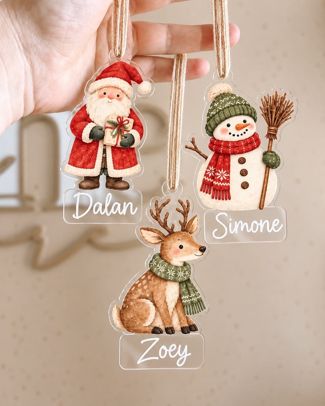 Three clear acrylic Christmas ornaments with Santa, a reindeer, and a snowman characters.