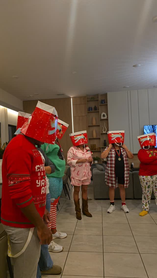 Adults wearing red and white buckets on their heads during a holiday party.