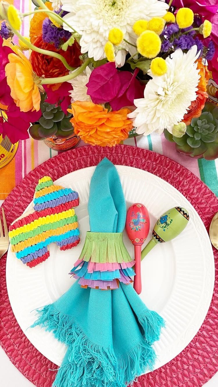 Turquoise fabric napkin with colorful ruffled ring on a festive table setting