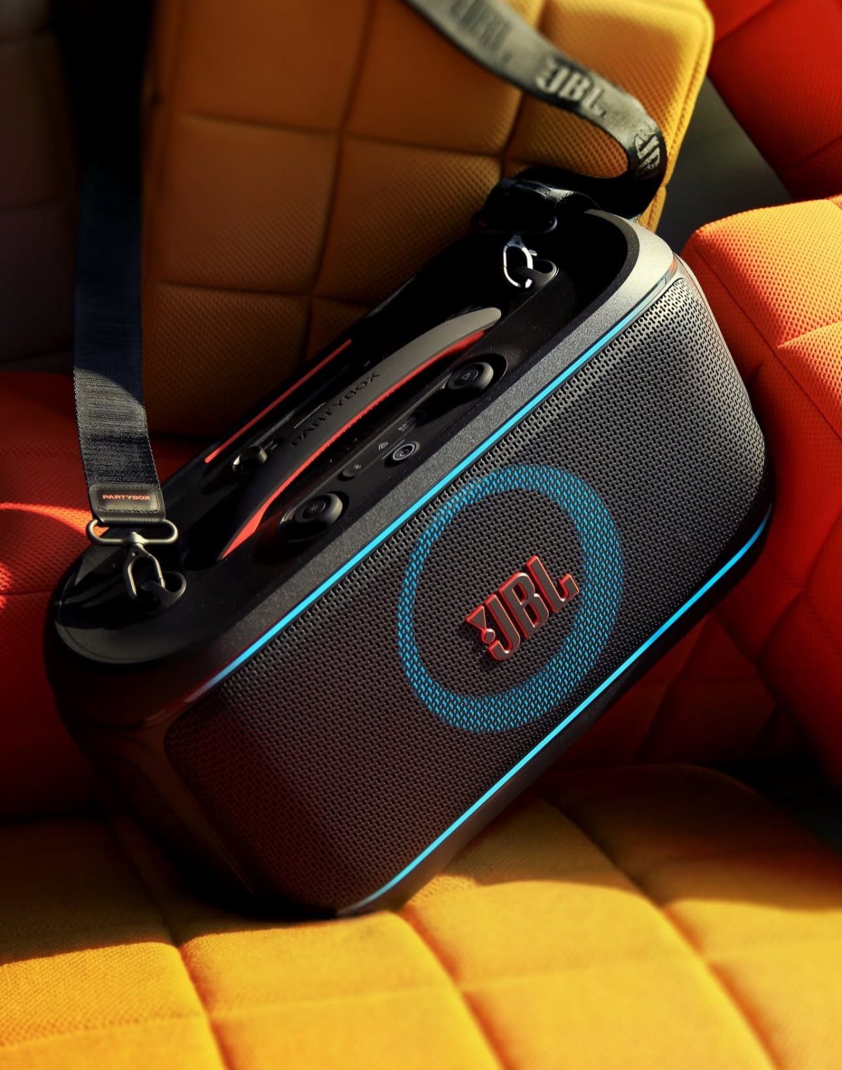 Black JBL portable speaker with blue accents on yellow quilted fabric