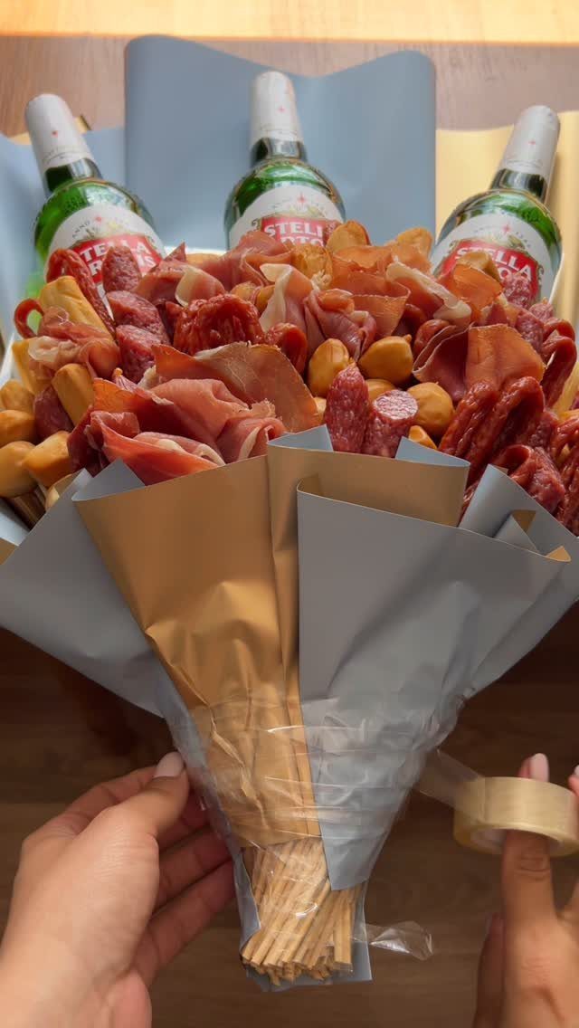 Meat and beer bouquet wrapped in paper, featuring Stella Artois bottles and charcuterie.