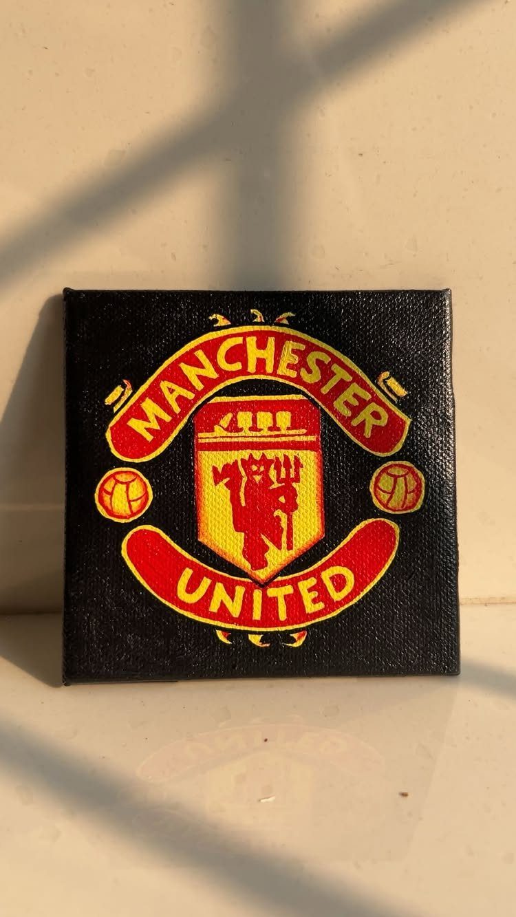Manchester United logo hand-painted on a small black square canvas