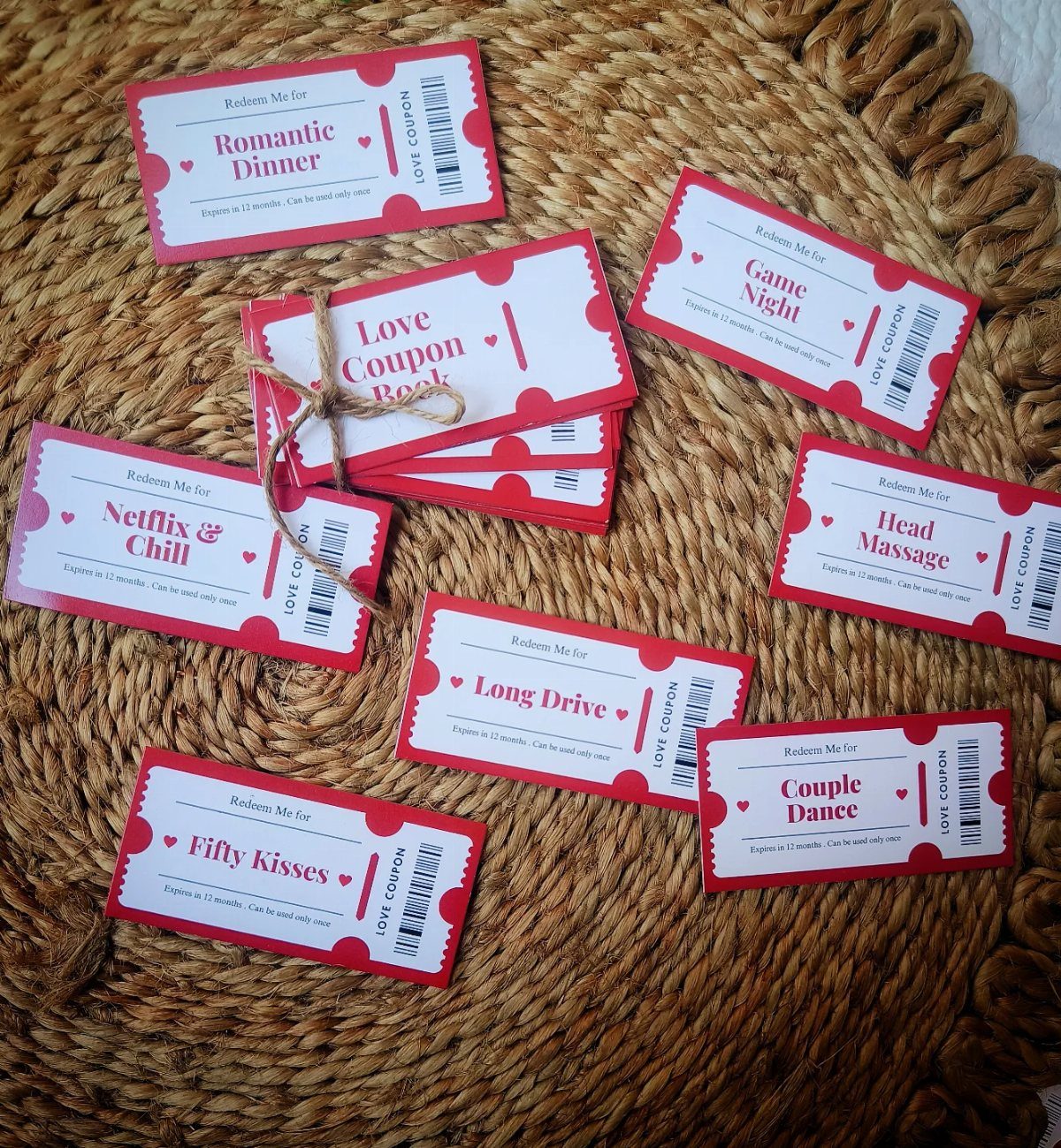 Love coupon book and individual red tickets scattered on a woven straw mat.