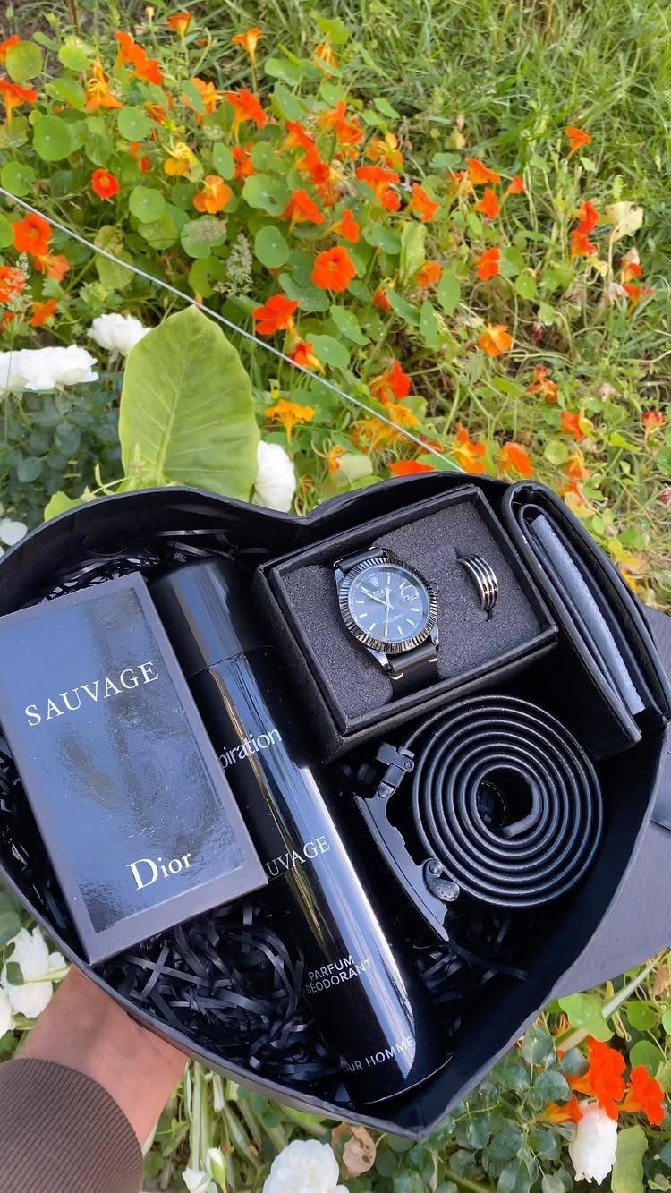 Heart-shaped gift box containing Dior fragrance, silver watch, ring, and black belt.