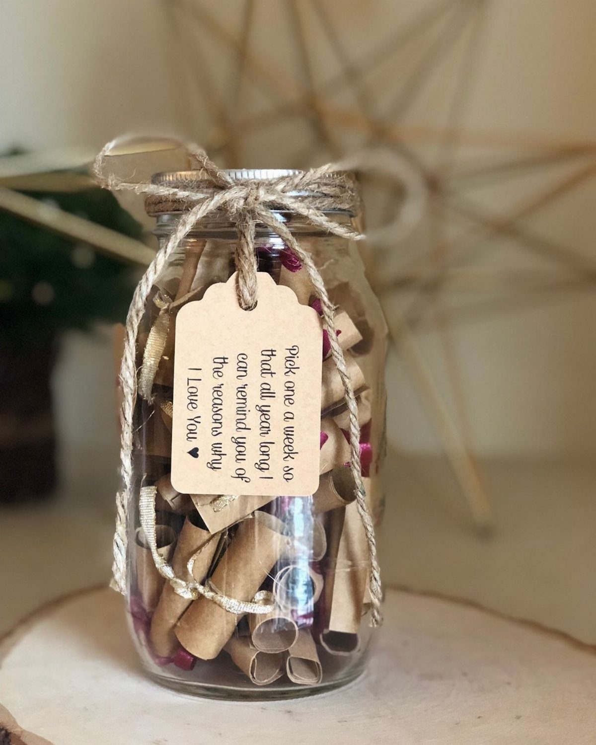Glass jar filled with rolled brown paper notes and a handwritten tag.
