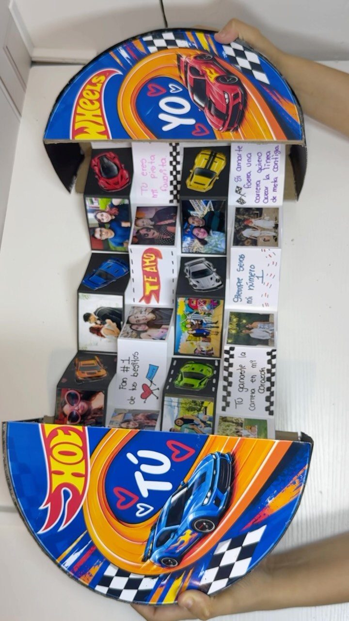 Handmade explosion box with Hot Wheels theme, containing photos, notes, and toy cars.