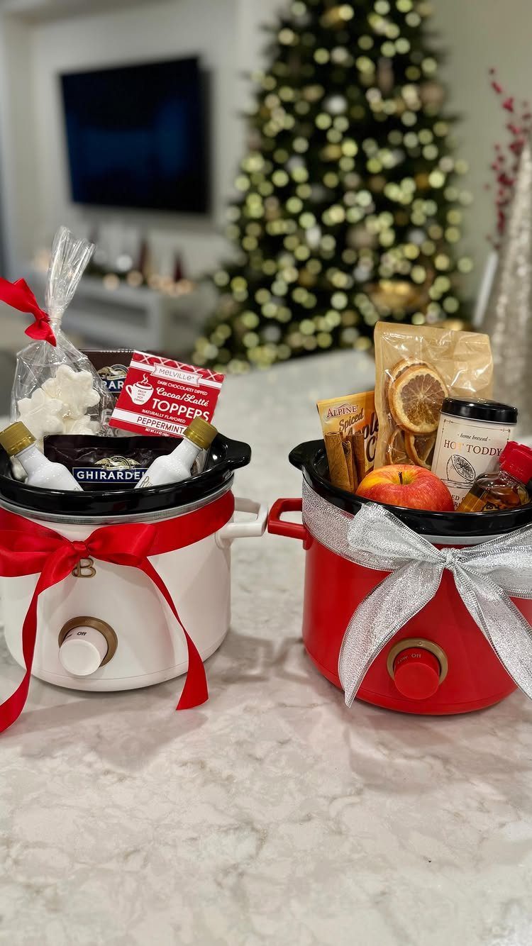 Two slow cookers filled with gourmet food gifts and tied with festive ribbons.