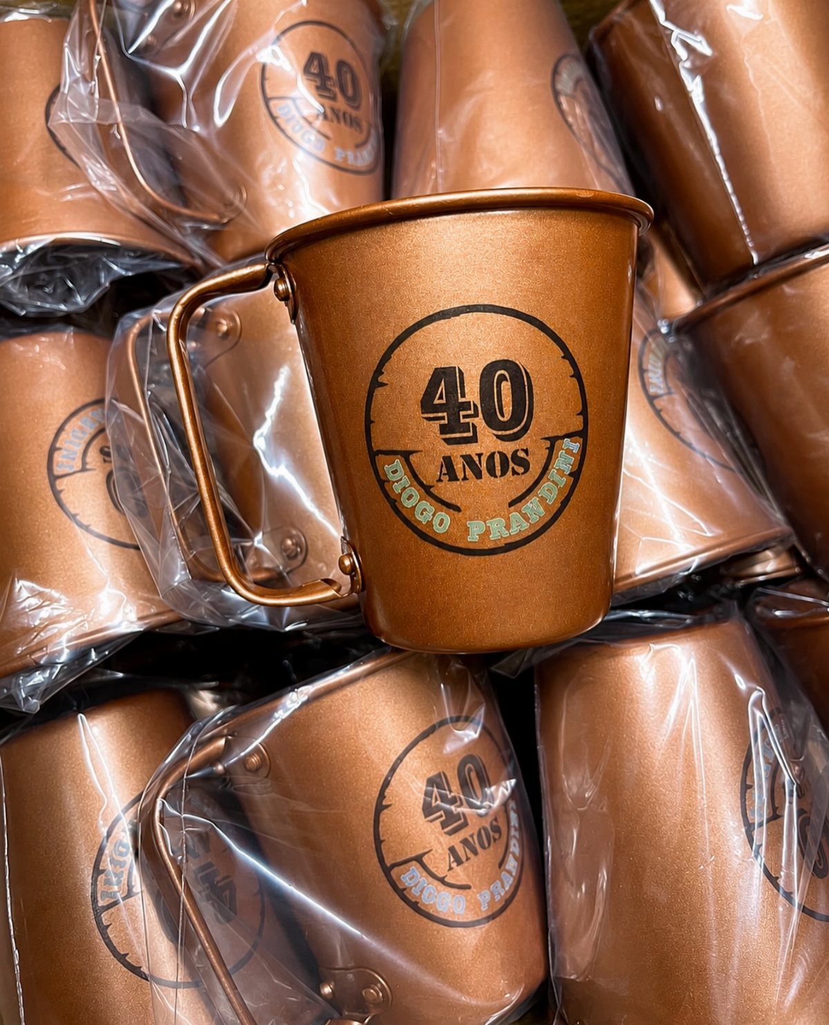 Copper metal mugs with a custom 40th birthday logo and name printed on them.
