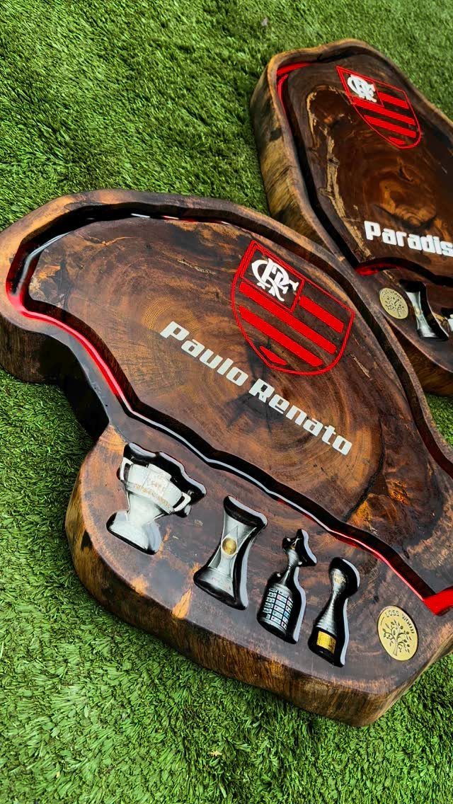 Custom wooden trays with a sports crest, name, and trophy figurines on grass
