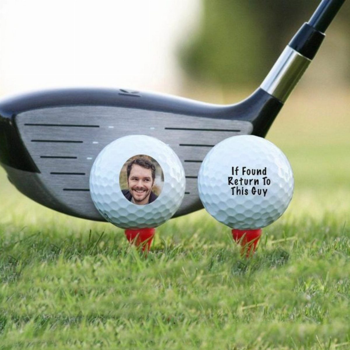 Two personalized golf balls on red tees with a photo and custom text.