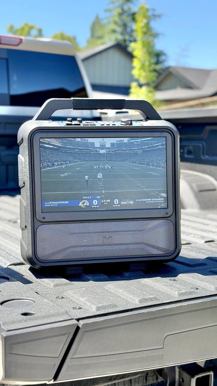 Portable rugged screen displaying a football game in a pickup truck bed