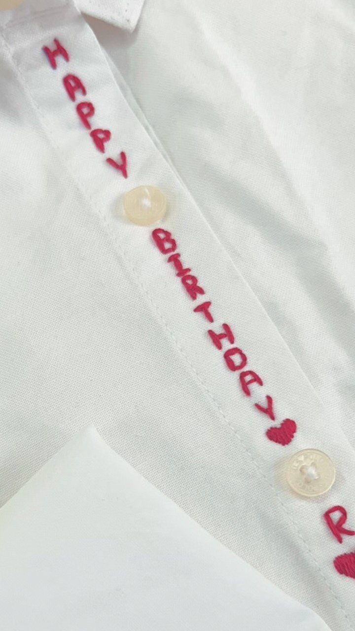 White button-down shirt with red embroidered Happy Birthday text on the inner placket.