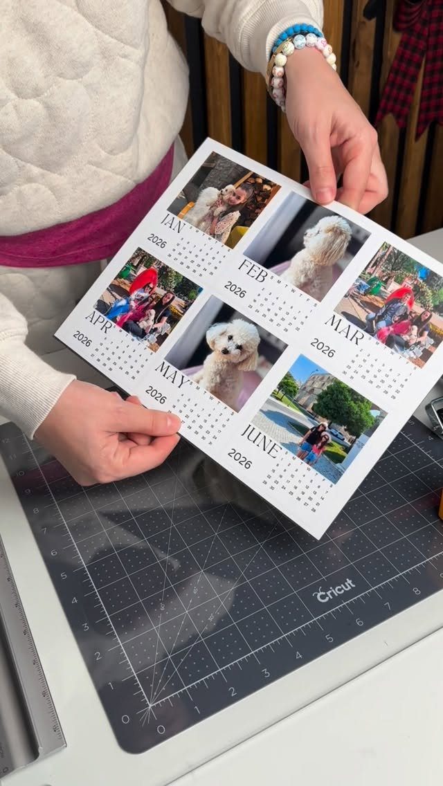 Person holding a personalized photo calendar with pictures of a dog and family.