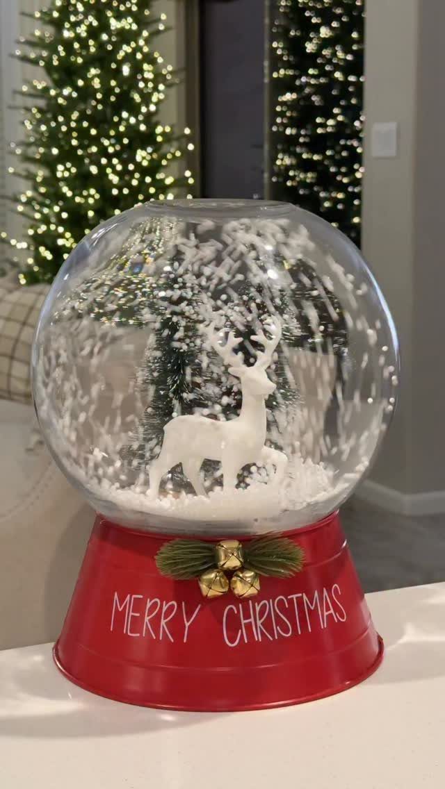 Snow globe with a white reindeer on a red Merry Christmas base.