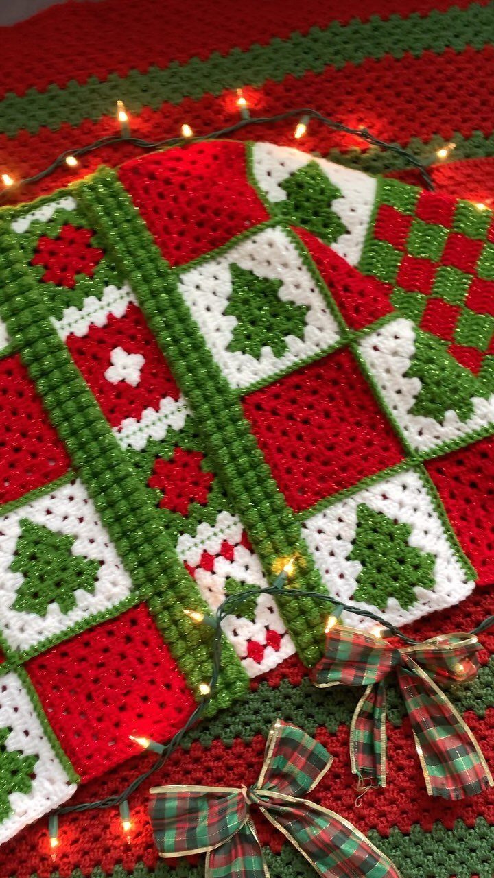 Crocheted Christmas blanket with tree patterns, fairy lights, and plaid ribbons.