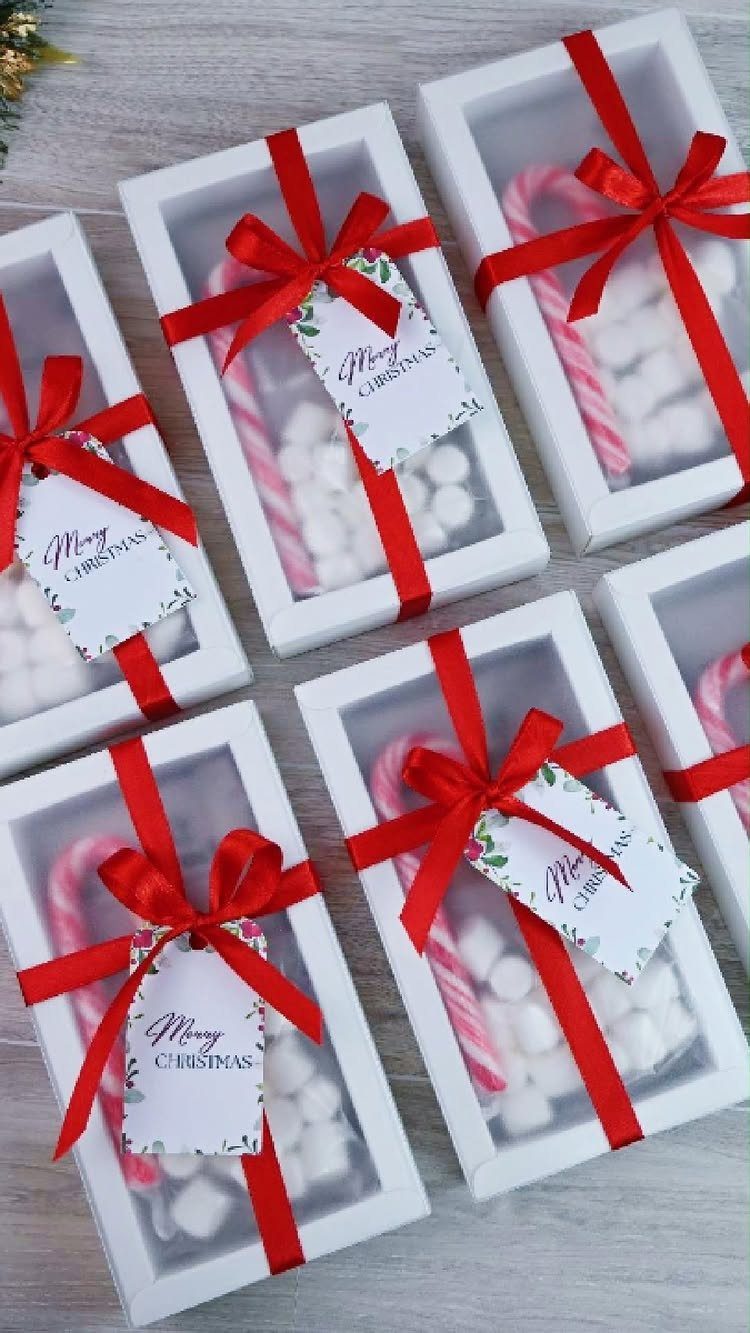 White gift boxes with candy canes and marshmallows tied with red ribbons